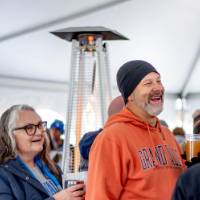 Guests laugh in the Alumni Tent